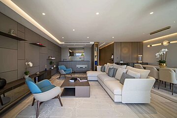 A living room with a white couch and blue chairs