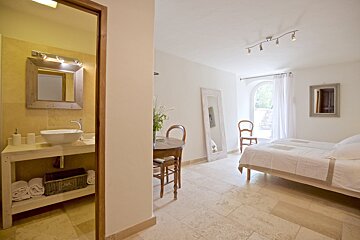 A bathroom with a sink and a mirror and a bed