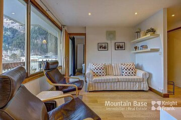 A living room with a couch and chairs and a sign that says mountain base