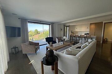 A living room with a couch and chairs and a welcome sign on the table