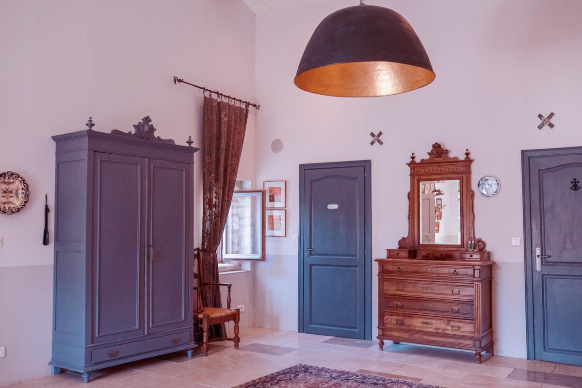 A room with a blue door and a dresser