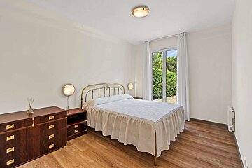 A bedroom with a large bed and a dresser
