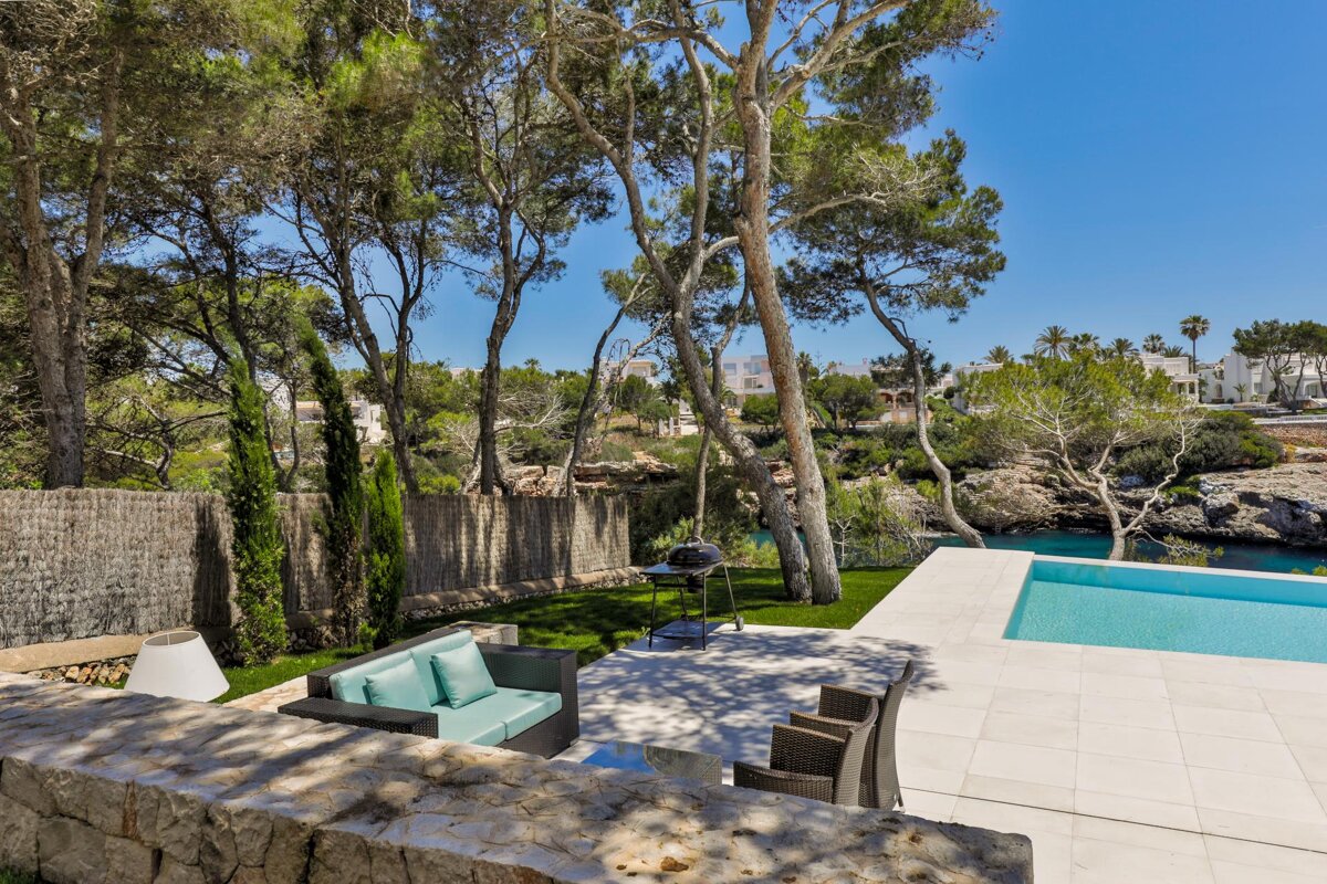 A patio with a couch and chairs next to a pool