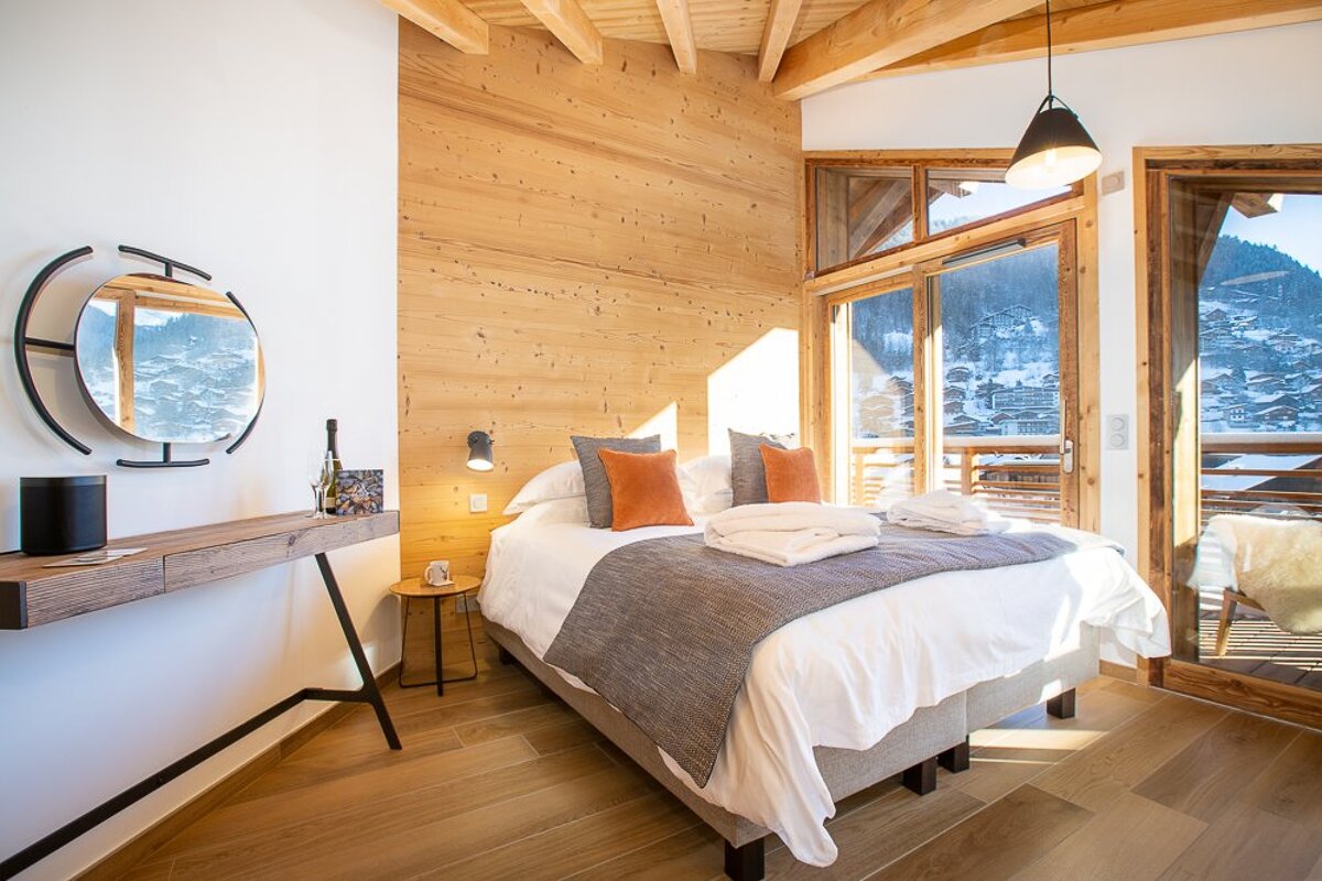 A bedroom with a large bed and a mirror