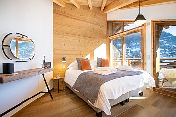 A bedroom with a large bed and a mirror