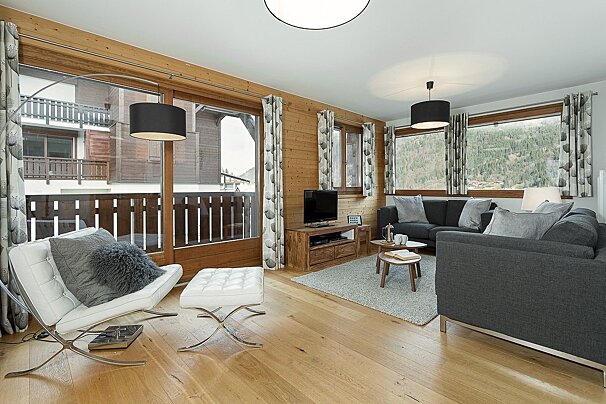 A living room with a couch a chair and a television