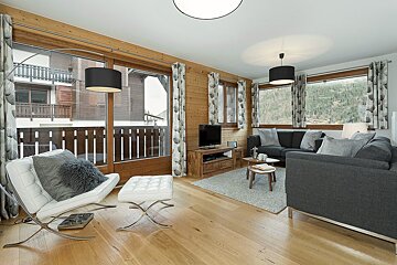 A living room with a couch a chair and a television