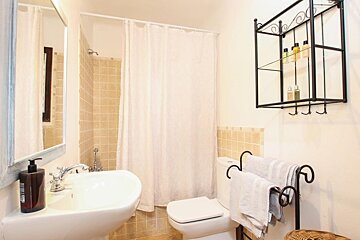 A bathroom with a toilet a sink and a mirror