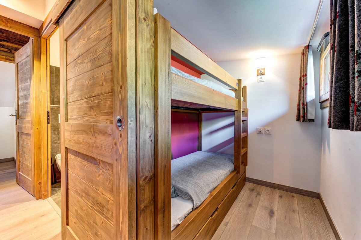 Cozy cabin bedroom featuring built-in wooden bunk beds and a matching sliding wooden door.
