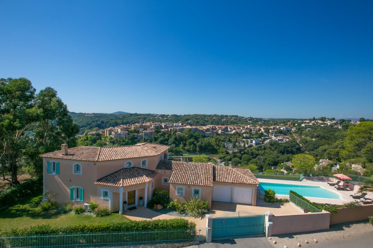 A large house with a swimming pool in front of it