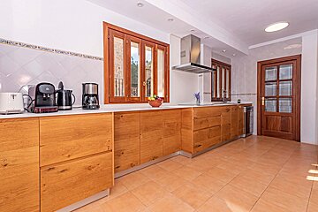 A kitchen with wooden cabinets and appliances including a coffee maker