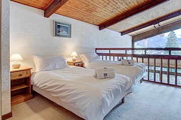 A bedroom with two beds and a picture on the wall
