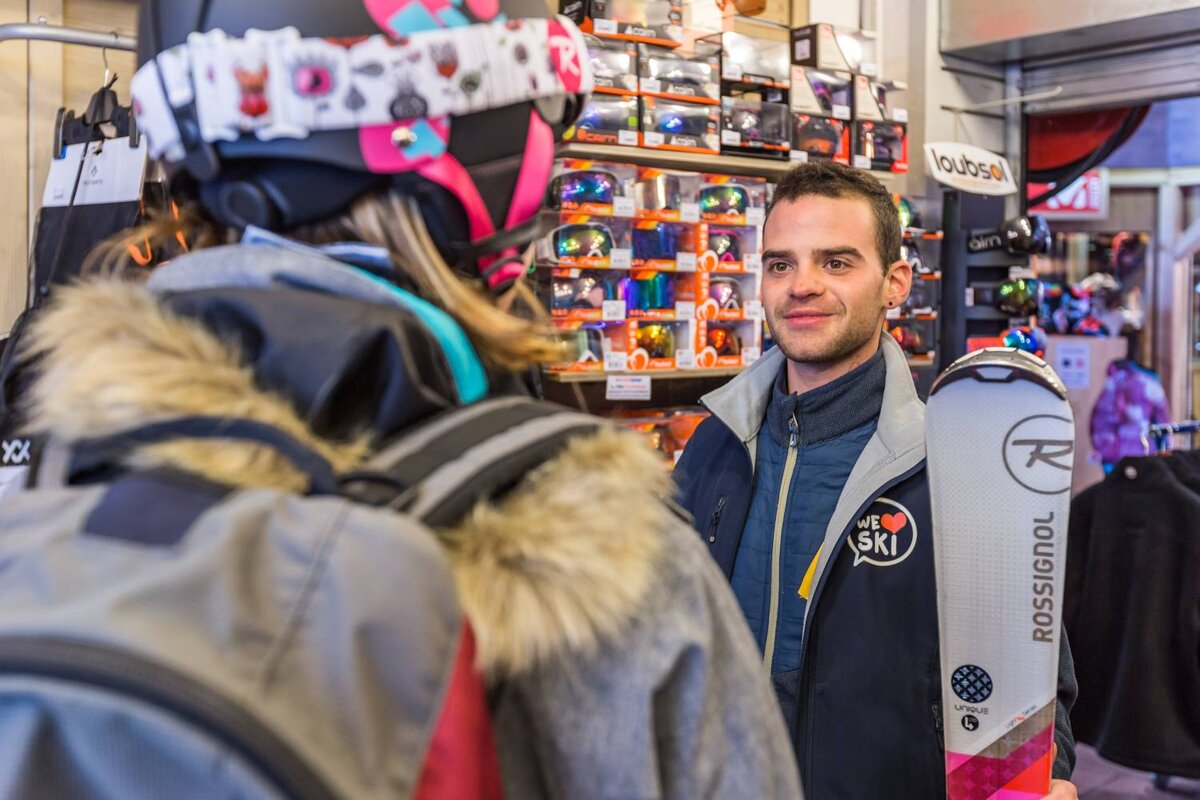A man holding a pair of skis that say rossignol