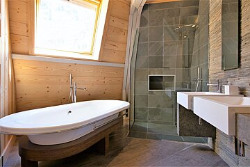 A bathroom with a bathtub and two sinks