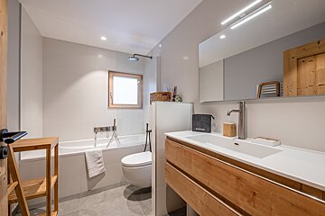 A bathroom with a sink toilet and bathtub and a towel that says ' eduscho ' on it