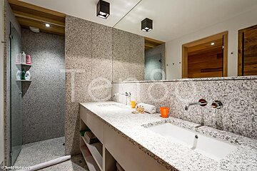 A bathroom with two sinks and a shower has the word holidays on the bottom right