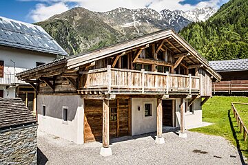 A wooden house with a mountain in the background