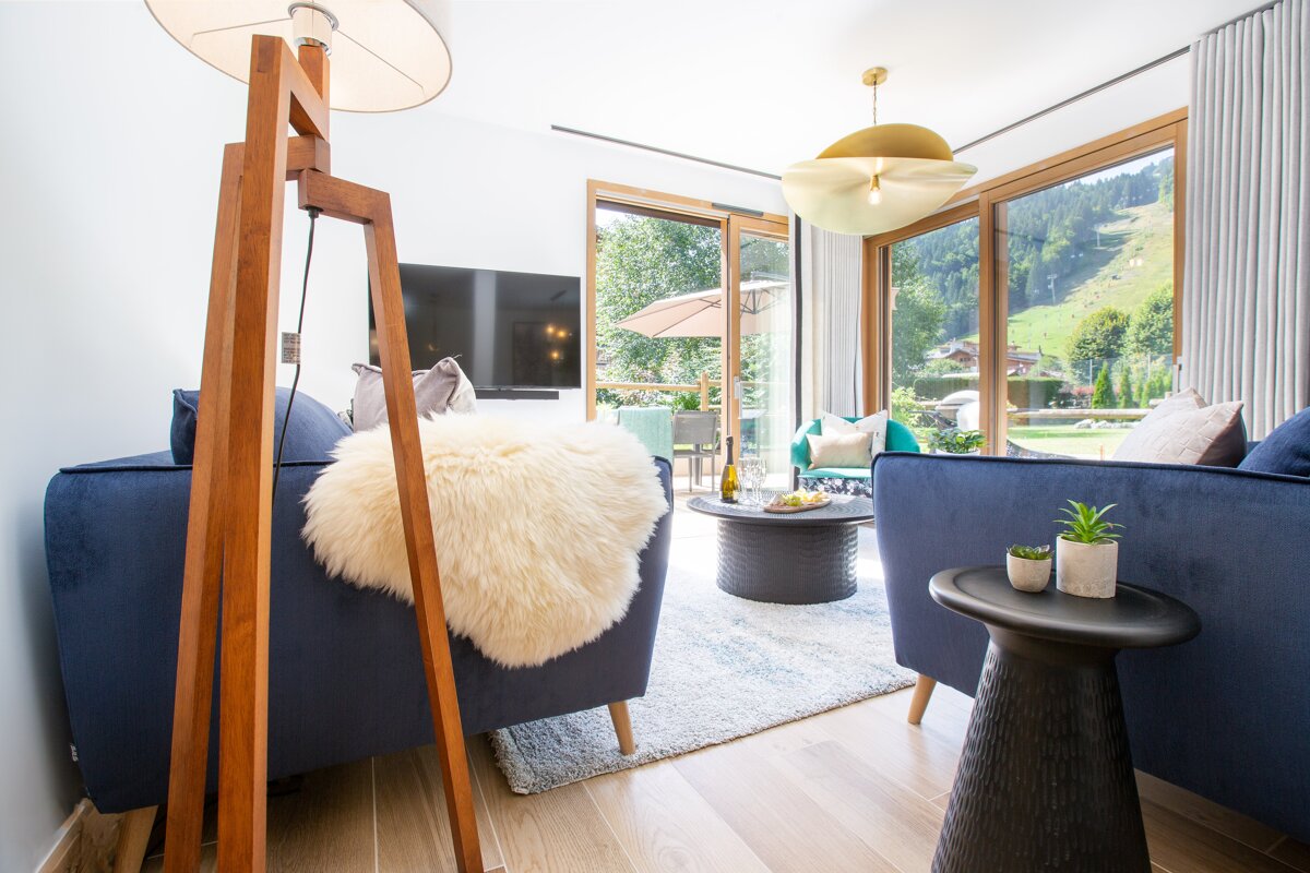 A living room with a blue couch and two chairs