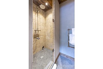 A bathroom with a walk in shower and a towel rack