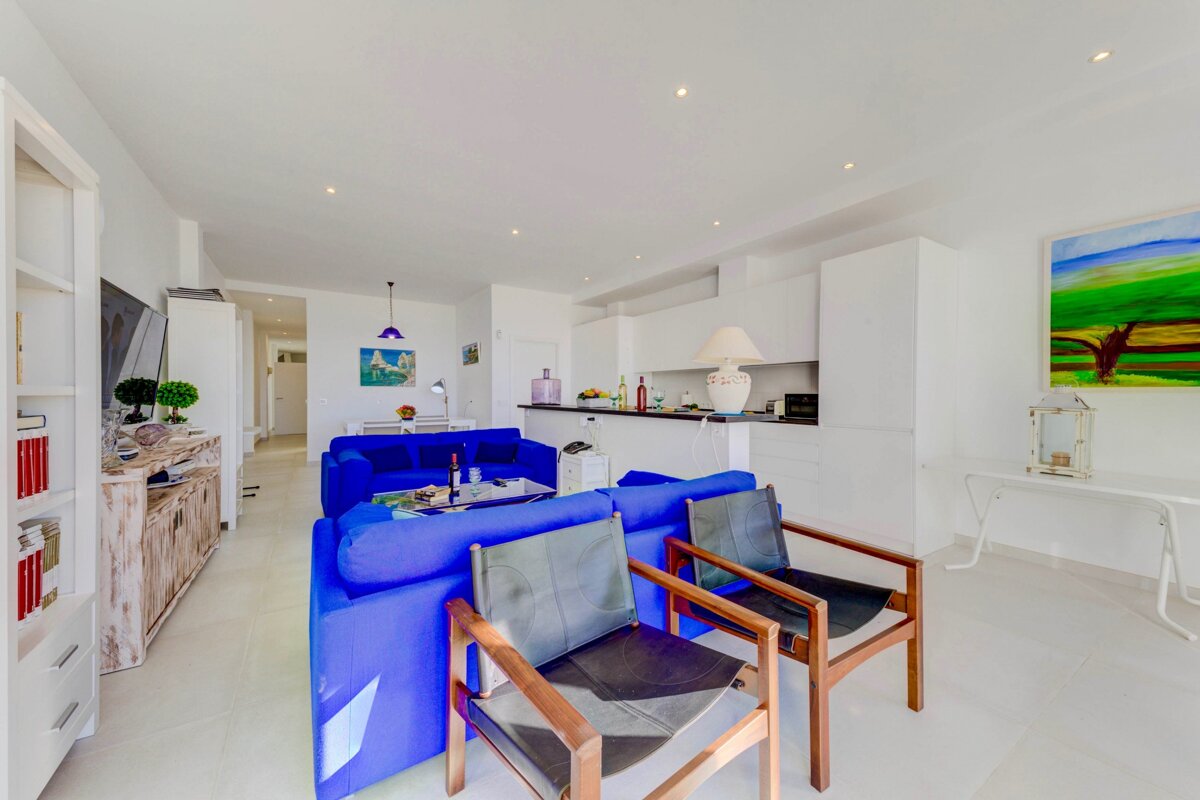 A living room with a blue couch and two chairs