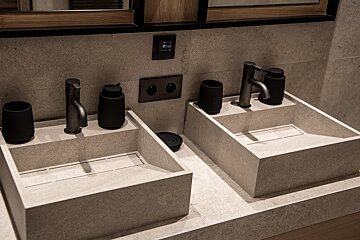 A bathroom with two sinks and a thermostat that says 11:42