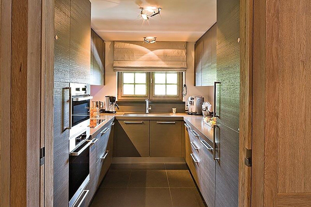A narrow kitchen with a sink and a window