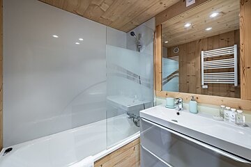 A bathroom with a bathtub a sink and a mirror