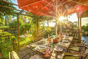 The sun is shining through the umbrella over the table
