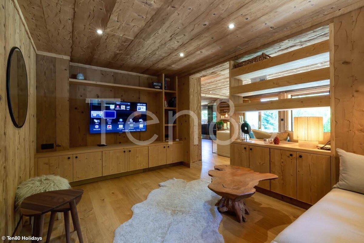 A living room with a flat screen tv and the word ten80 on the wall