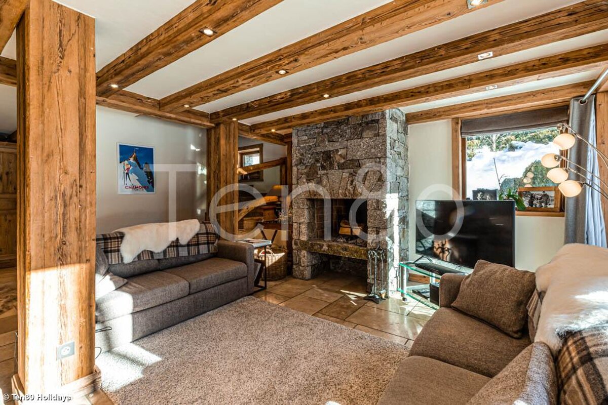 A living room with a stone fireplace and a couch