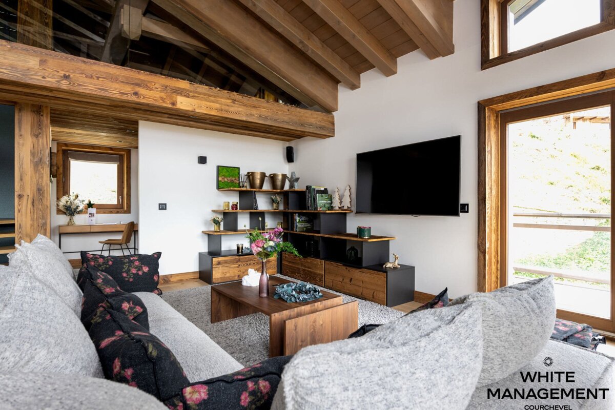 A living room with a rental designer logo in the corner