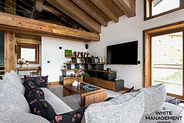 A living room with a rental designer logo in the corner
