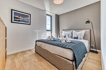 A bedroom with a large bed and a picture on the wall that says temp