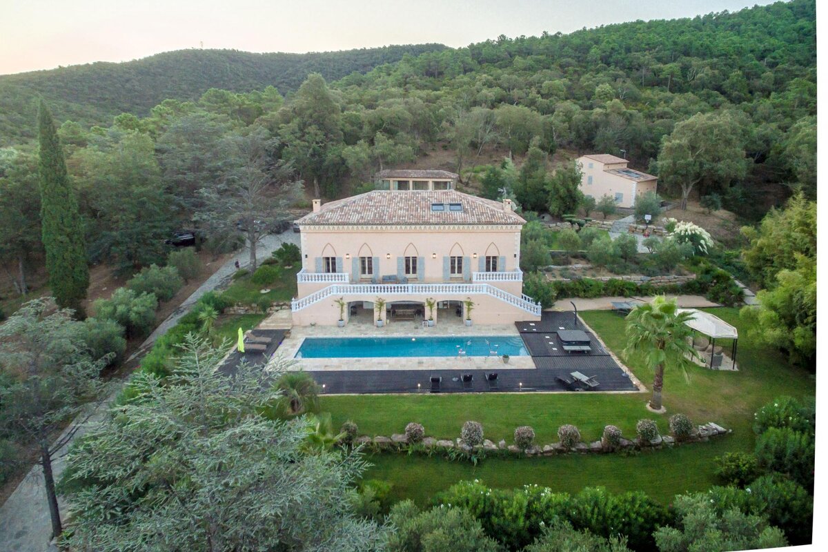 An aerial view of a large house with a swimming pool