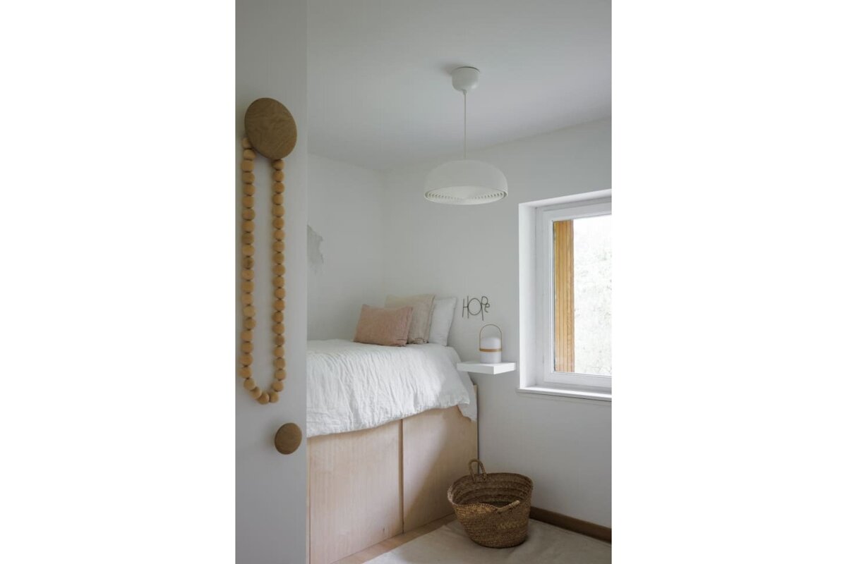 A bedroom with a bed and a basket with the word hope on it