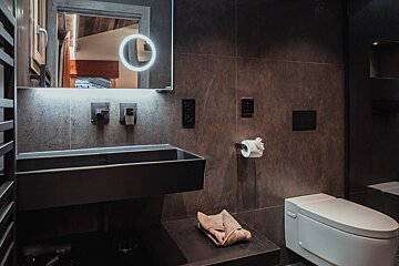 A bathroom with a toilet a sink and a mirror