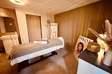 A payot sign hangs above a massage table