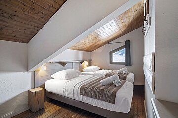A bedroom with two twin beds and a window