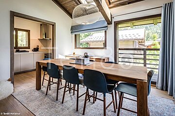 A dining room with a wooden table and blue chairs