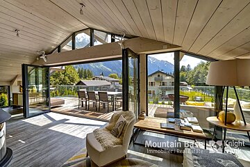 A living room with a mountain base knight real estate logo