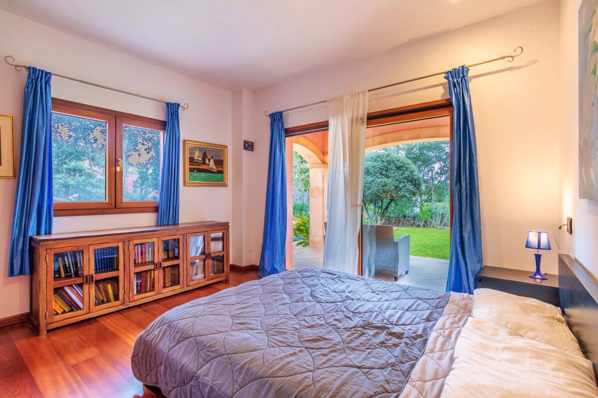 A bedroom with a large bed and blue curtains