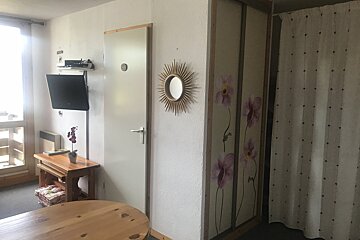 A room with a mirror and flowers on the wall