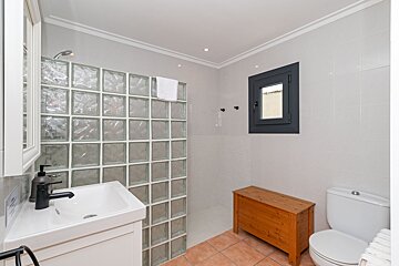 A bathroom with a sink toilet and a window