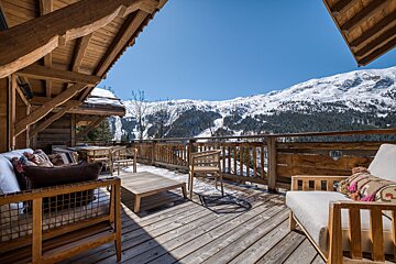 A wooden deck with a view of snow covered mountains