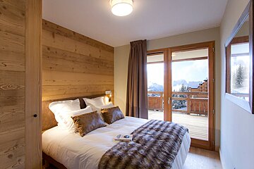 A bedroom with a large bed and a sliding glass door