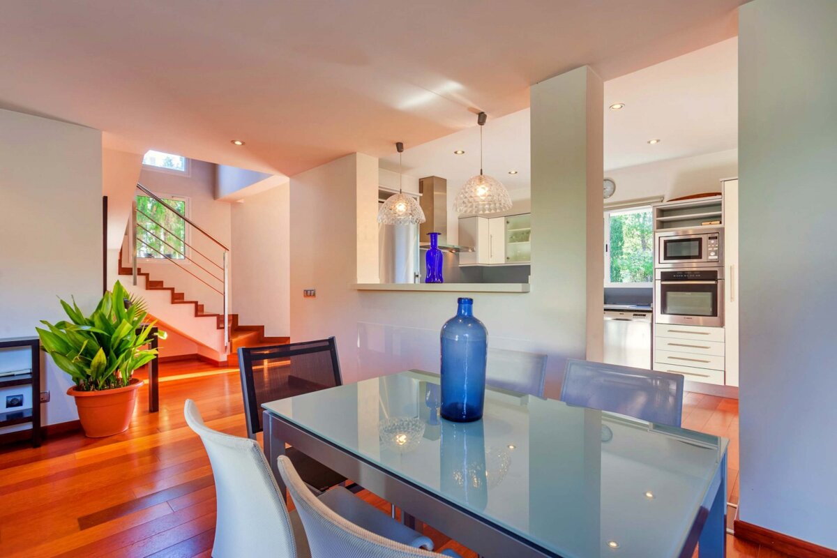 A dining room table with a blue vase on it
