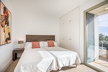 A bedroom with two beds and a painting on the wall