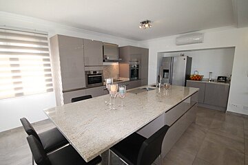 A kitchen with a large granite counter top