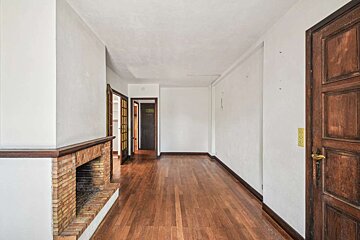 A long hallway with hardwood floors and a fireplace