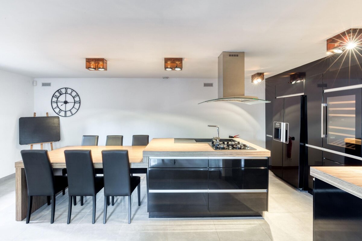 A kitchen with black cabinets and a clock on the wall
